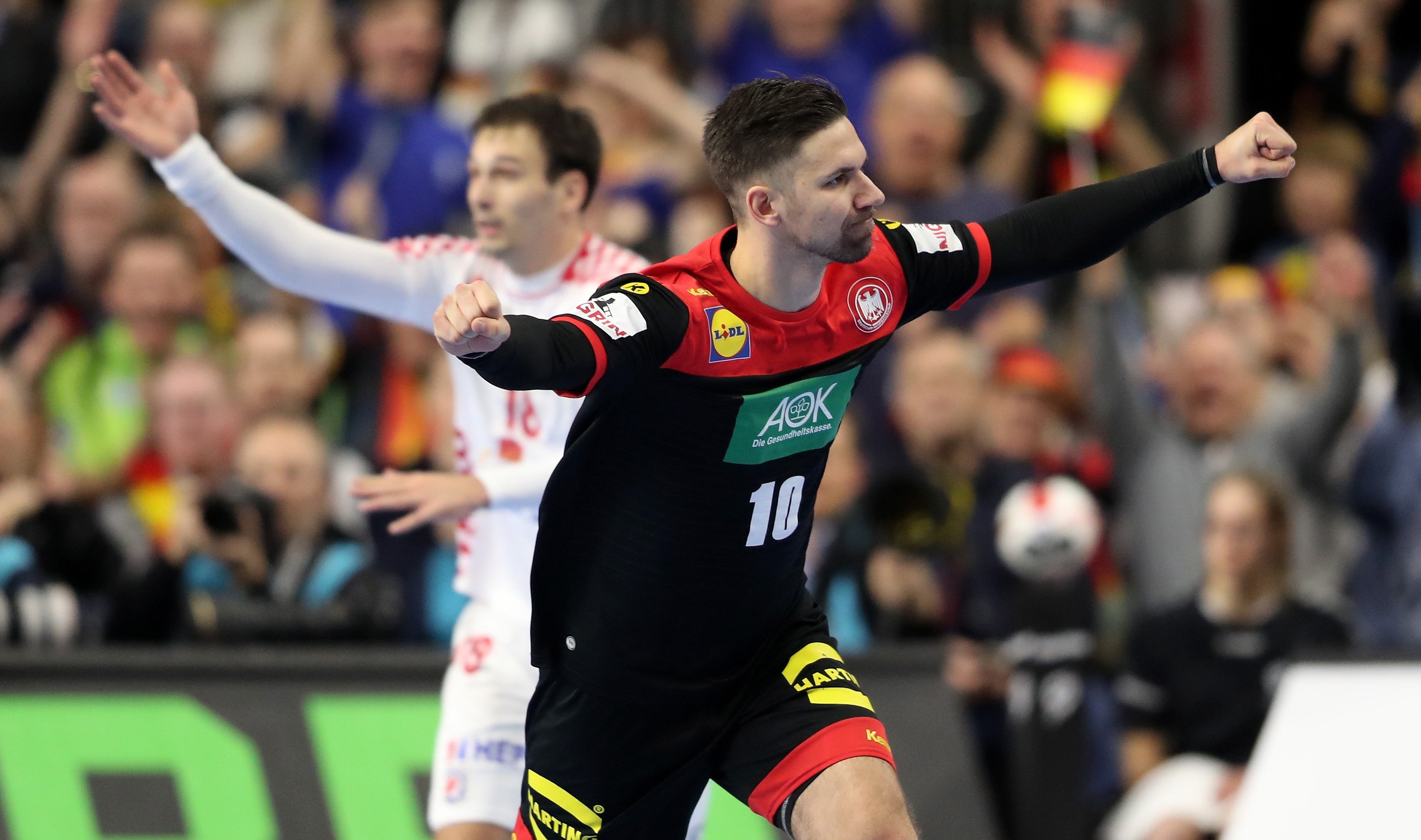 epa07307340 Fabian Wiede (L) of Germany celebrates during the main round group one match between Croatia and Germany at the IHF Men's Handball World Championship in Cologne, Germany, 21 January 2019. EPA-EFE/FRIEDEMANN VOGEL